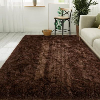 a living room with a brown rug on the floor