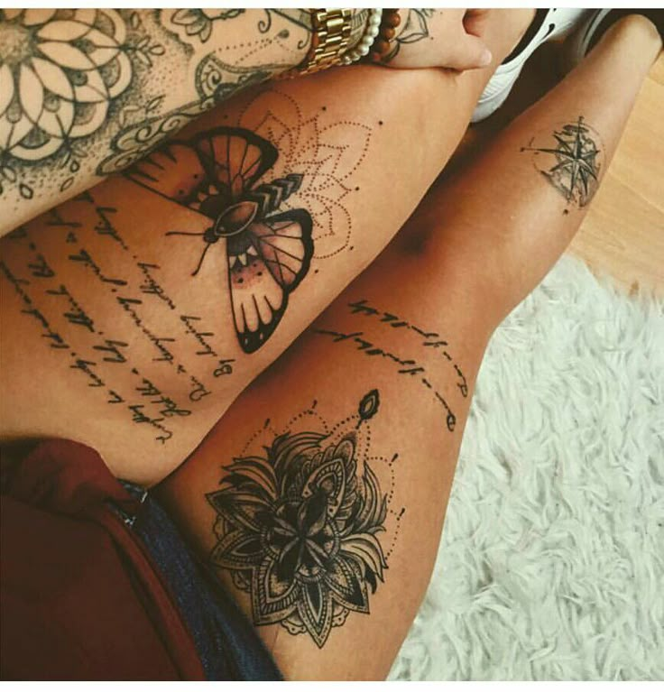 two women with tattoos on their legs sitting next to each other and holding cell phones