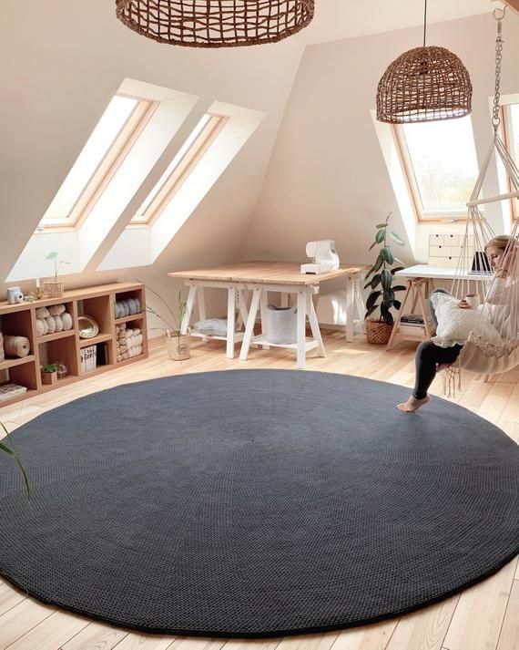 a woman is sitting on a hammock in the middle of a living room