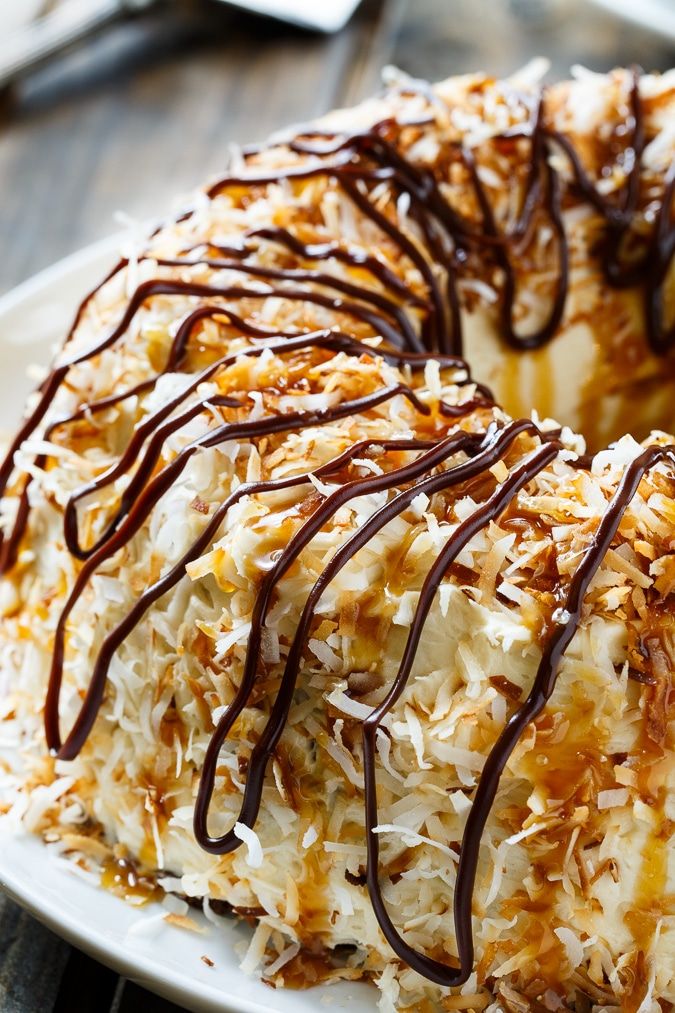 a bundt cake with coconut and chocolate drizzled on top