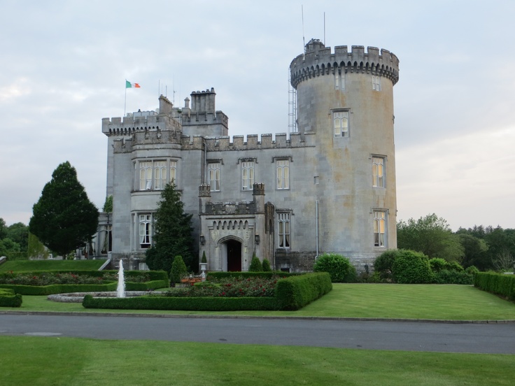 an old castle with a fountain in front of it and lots of greenery on the lawn