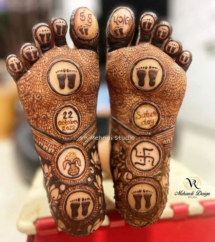 two feet covered in hendi with numbers and symbols painted on the bottom one foot