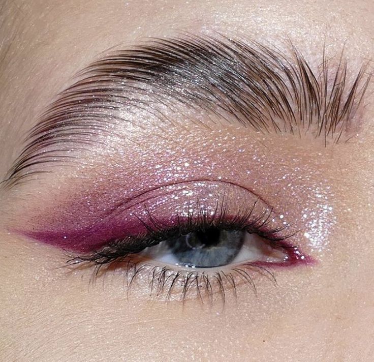 a close up shot of a woman's eye with pink and silver glitter on it