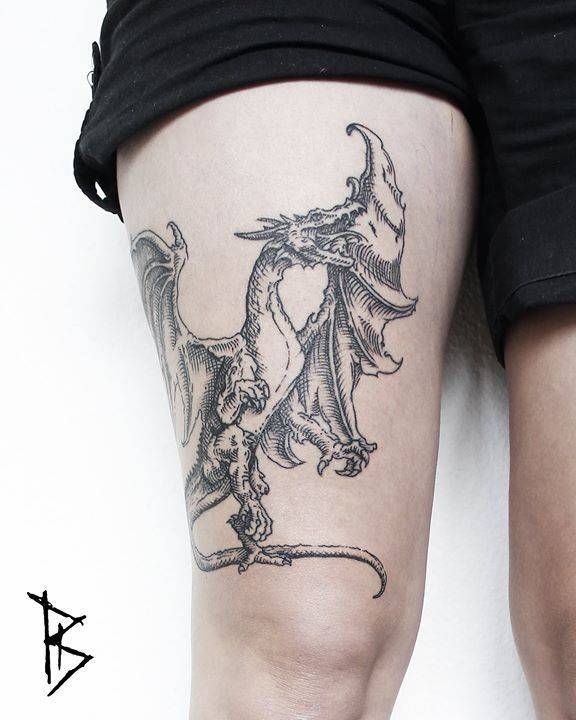 a woman's leg with a dragon tattoo on her thigh and the legs are covered in black ink