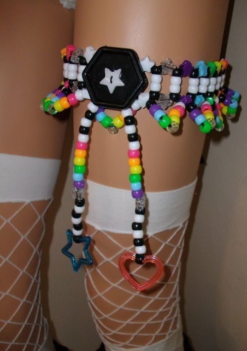 a close up of a person's legs wearing colorful bracelets and socks with charms on them