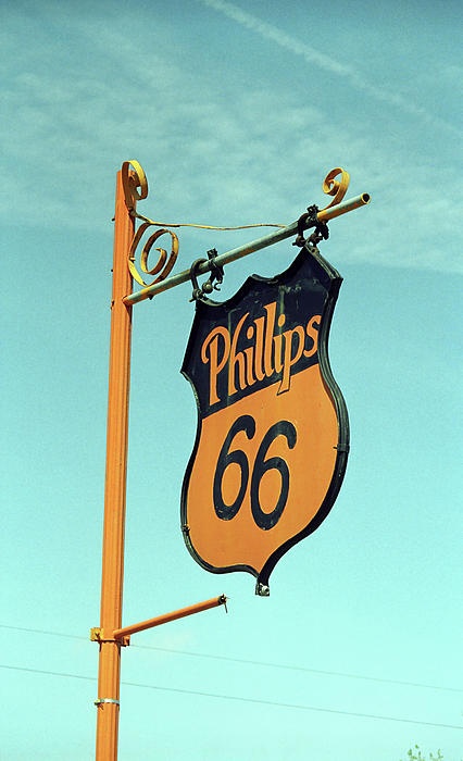 an old phillips 66 sign hanging from a pole