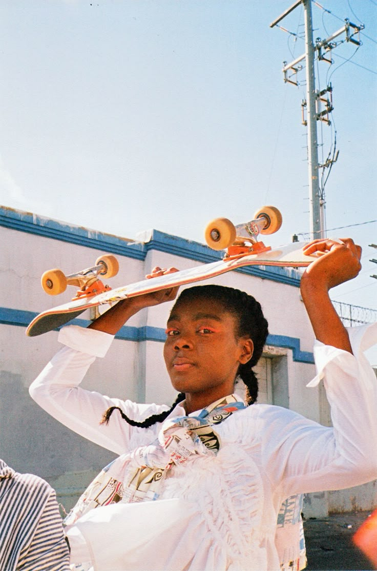 a woman holding two skateboards on her head