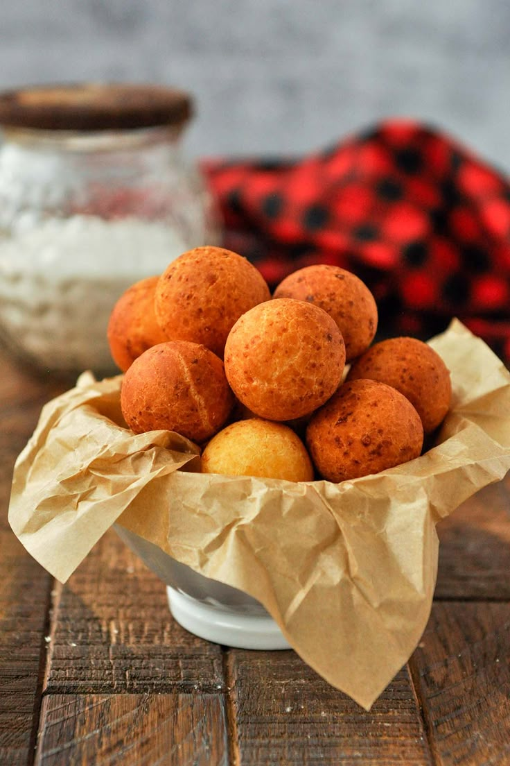 a white bowl filled with baked goods on top of a wooden table