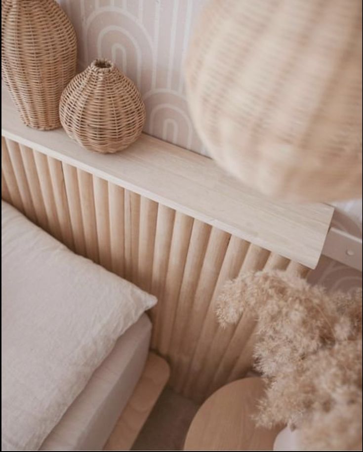 two wicker vases sitting on top of a wooden shelf next to a bed