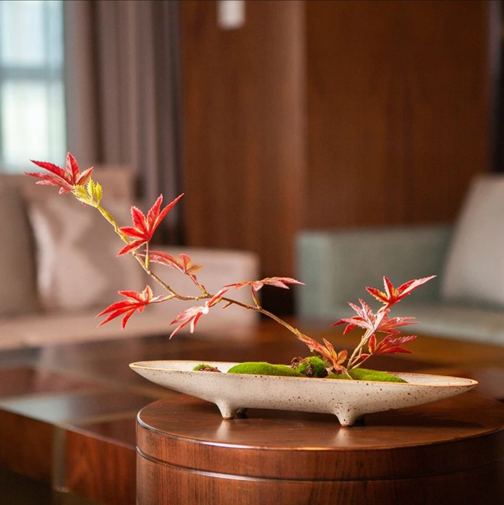 a table with a vase on top of it and a plant in the centerpiece