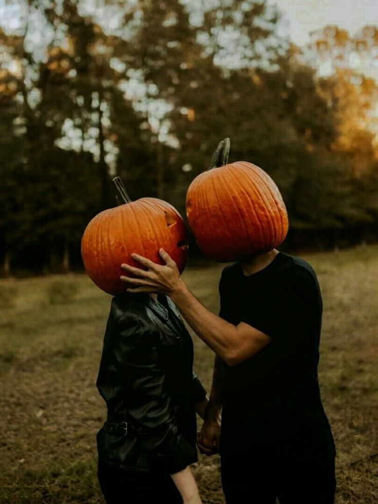 two people with pumpkins on their heads