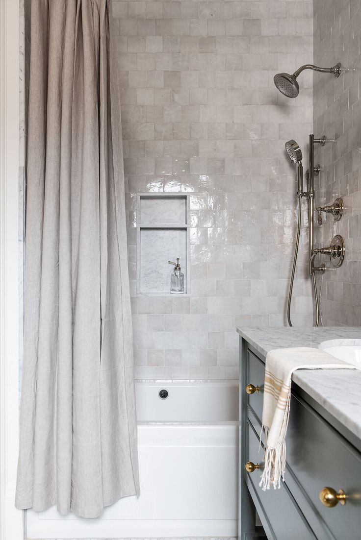 a bathroom with a sink, shower and bathtub next to a window in the wall