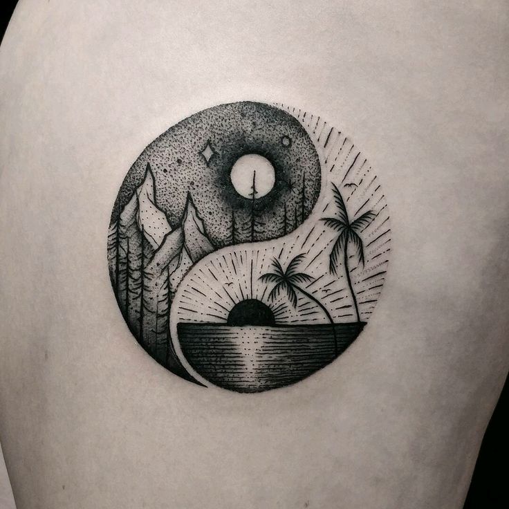 a black and white image of a yin - yang tattoo on the back of a woman's shoulder