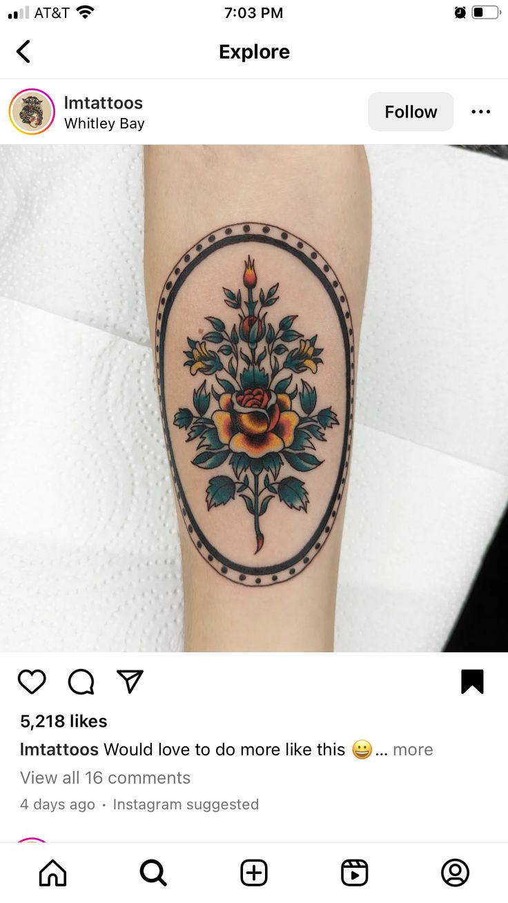 a tattoo with flowers on the arm and an image of a rose in a circle