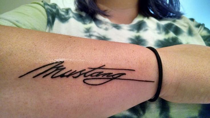 a woman with a tattoo on her arm that reads, muttagag in cursive writing