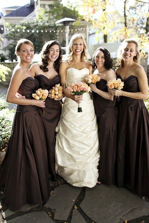 a group of women standing next to each other holding bouquets