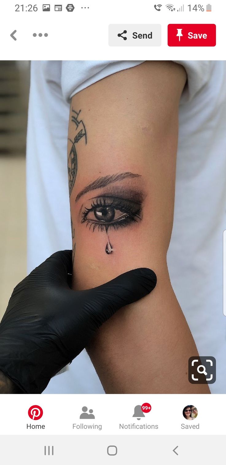 a person with a tattoo on their arm and eye looking at something in the distance