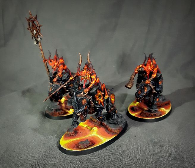 three painted warhammers with flames on them