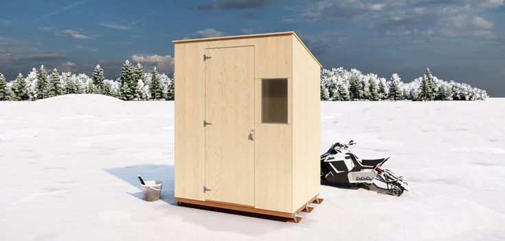 a small wooden outhouse sitting in the middle of a snow covered field next to skis