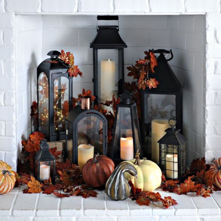 a fireplace with candles and pumpkins on it