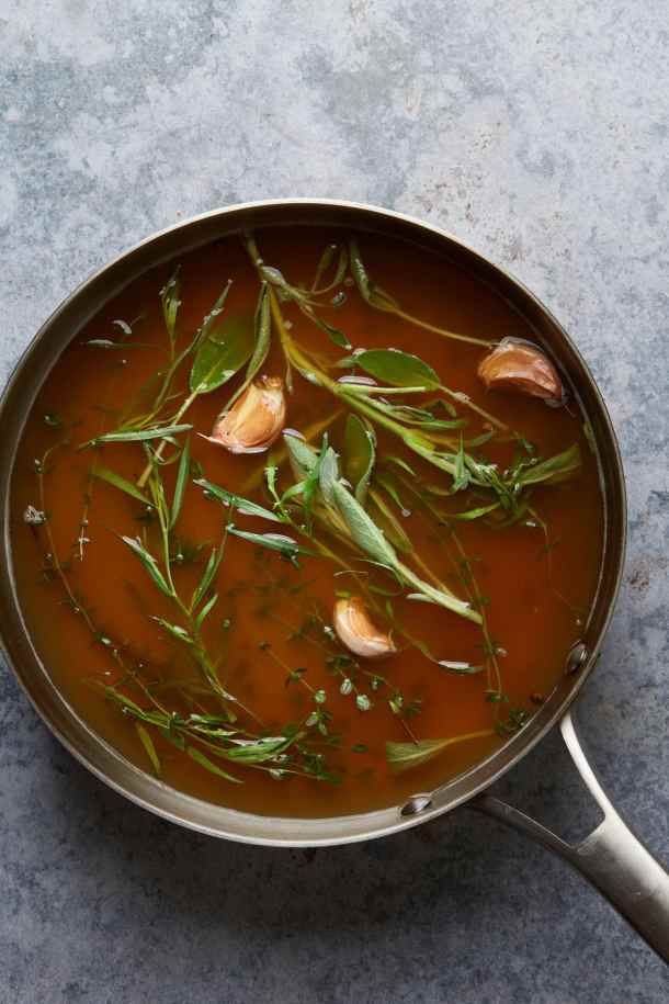 a pot filled with soup and herbs on top of a table