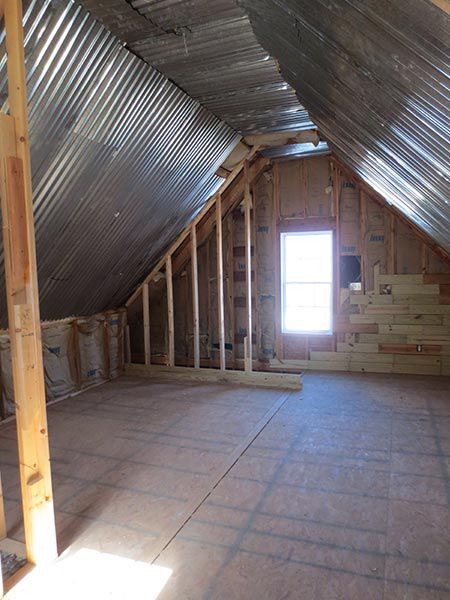 an attic with metal roofing and exposed walls