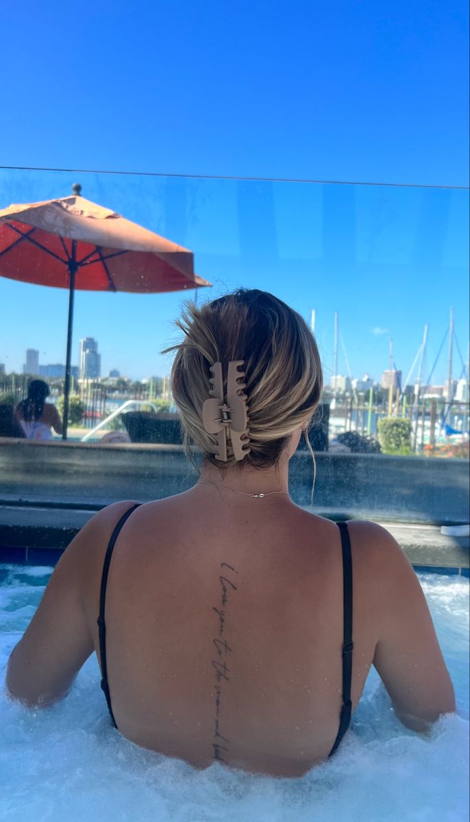 a woman sitting in the water with her back turned