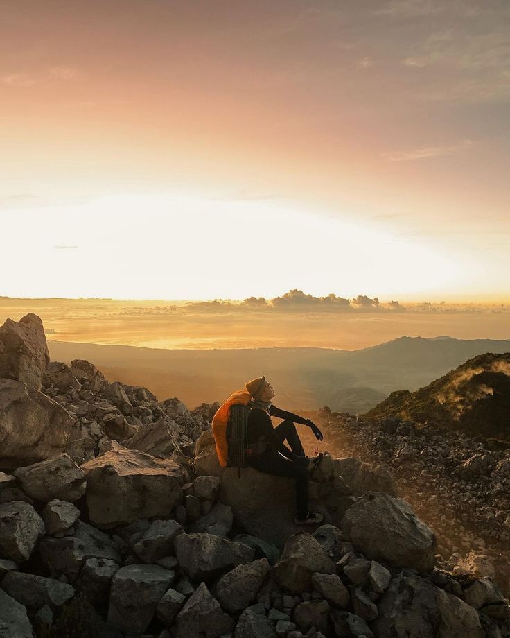 a man sitting on top of a pile of rocks