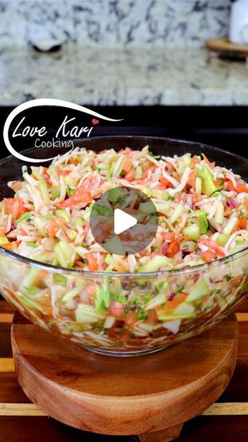 a glass bowl filled with coleslaw on top of a wooden cutting board