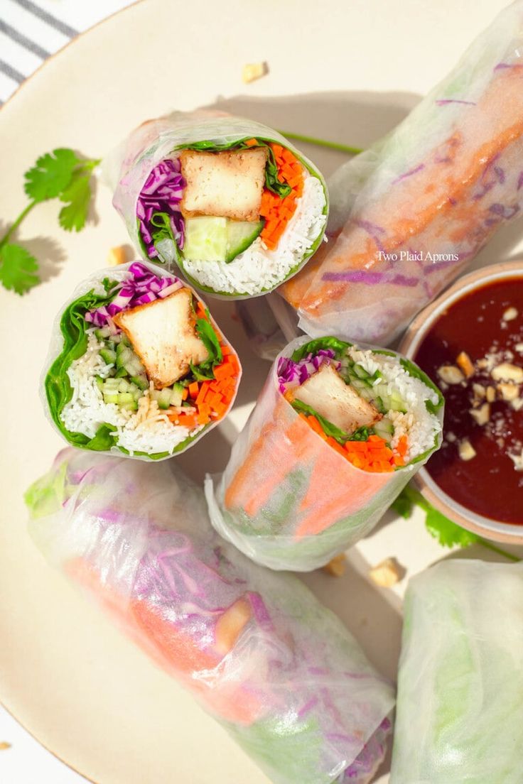 several rolls on a plate with dipping sauce