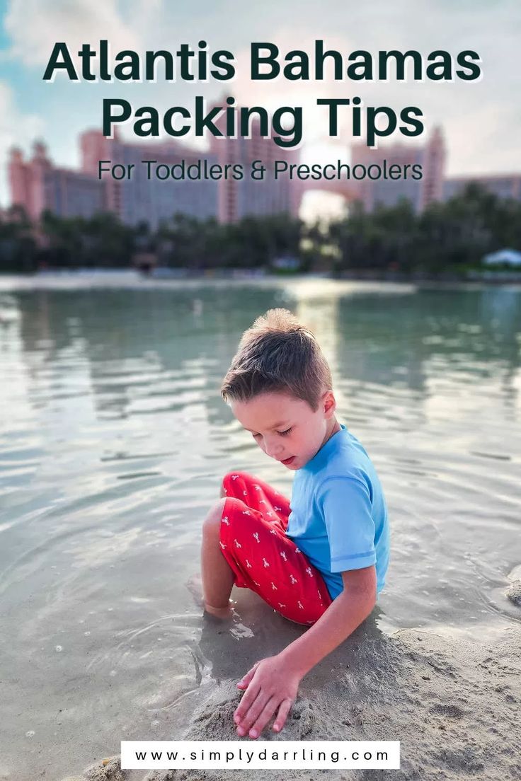 a young boy sitting on top of a sandy beach next to the ocean with text overlay