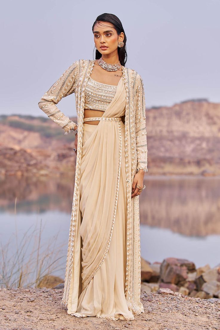 Indulge in sophistication with this stunning signature tone-on-tone drape sari set in georgette, accompanied by a fully embroidered blouse in silk. Completing the ensemble is an embellished cape an... Drape Sari, Drape Sarees, Ridhi Mehra, Cape For Women, Cape Set, Draped Saree, Backless Blouse Designs, Set Saree, Padded Blouse