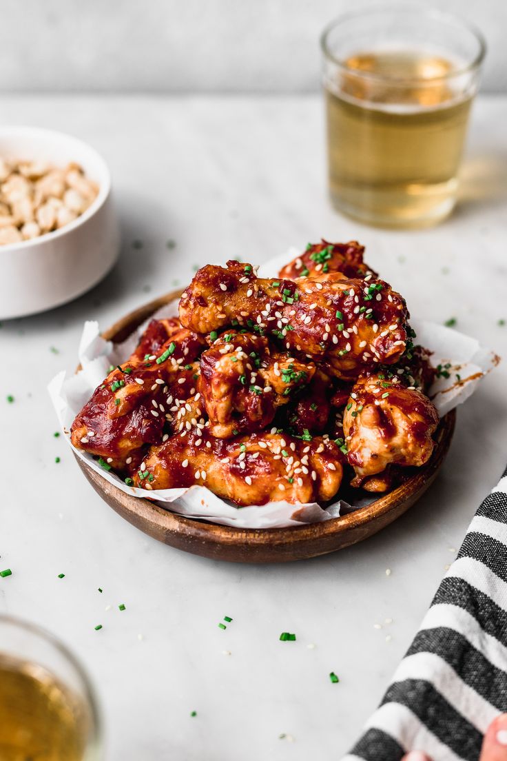 a plate filled with chicken wings covered in sesame seeds