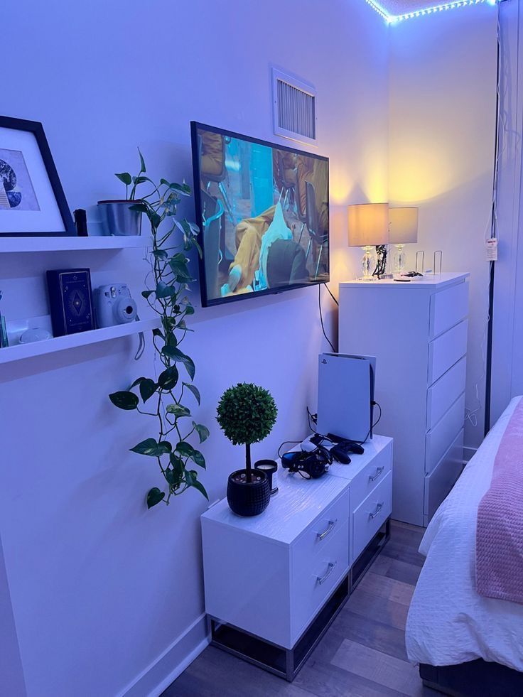 a bedroom with a bed, dresser and tv on the wall in it's corner