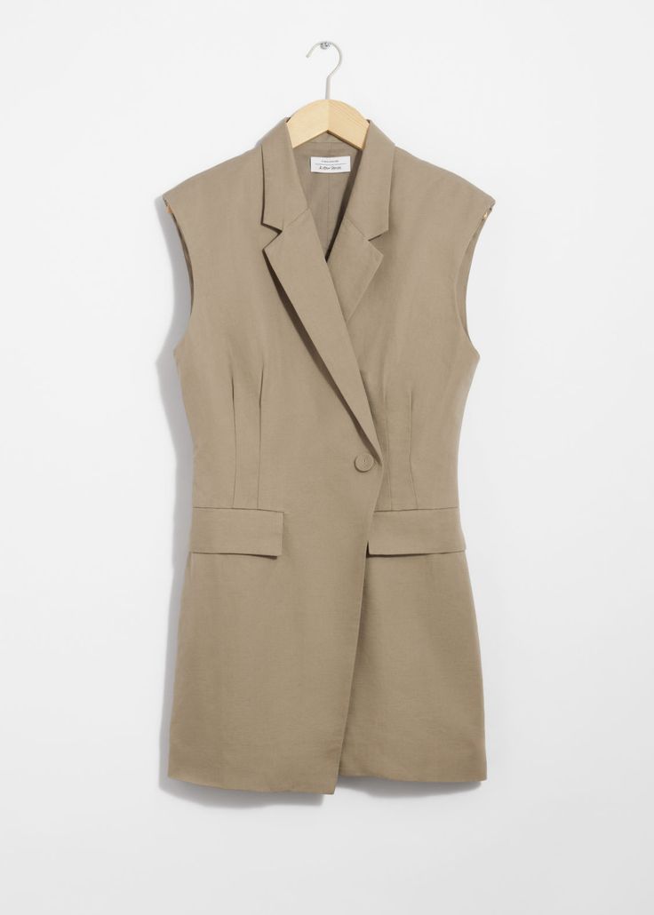 Sleeveless blazer mini dress featuring an accentuated waistline and padded shoulders for a structured silhouette.• V-cut neckline• Overlapping, single-button lapel• Duo welt pockets• Buckle detail at the back for an adjustable fit• Length of dress:86cm / 33.9" (EU 36 / UK 8 / US 4) Workwear Mini Dress With Structured Shoulders, Mini Dress With Structured Shoulders For Work, Chic Workwear Mini Dress With Structured Shoulders, Chic Mini Dress With Structured Shoulders For Work, Semi-formal Sleeveless Blazer With Hidden Button Closure, Semi-formal Sleeveless Spring Blazer, Chic Spring Career Mini Dress, Spring Chic Career Mini Dress, Tailored Structured Mini Dress For Work