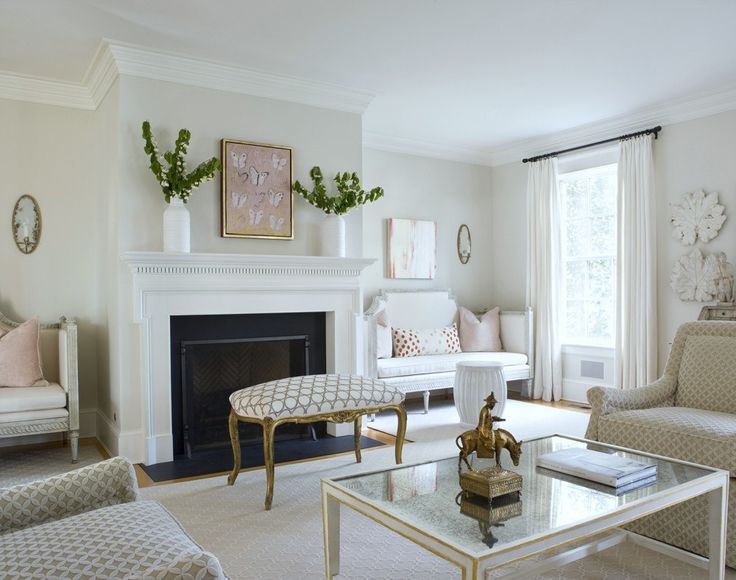 a living room filled with furniture and a fire place in front of a mirror on the wall