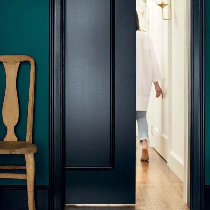 a person walking into a room with blue walls and a chair in front of the door