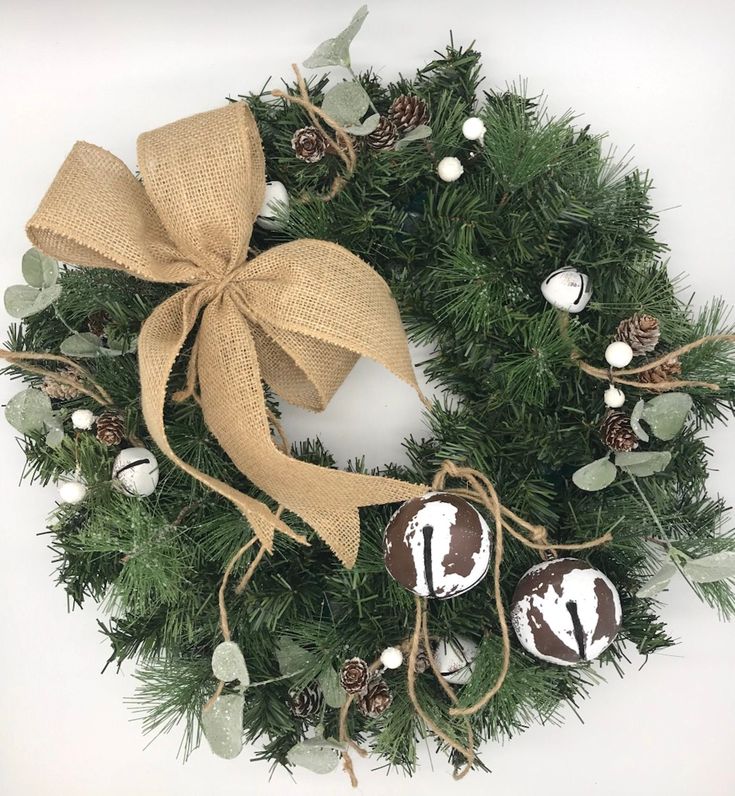 a christmas wreath with chocolates and pine cones on the front, tied in burlock