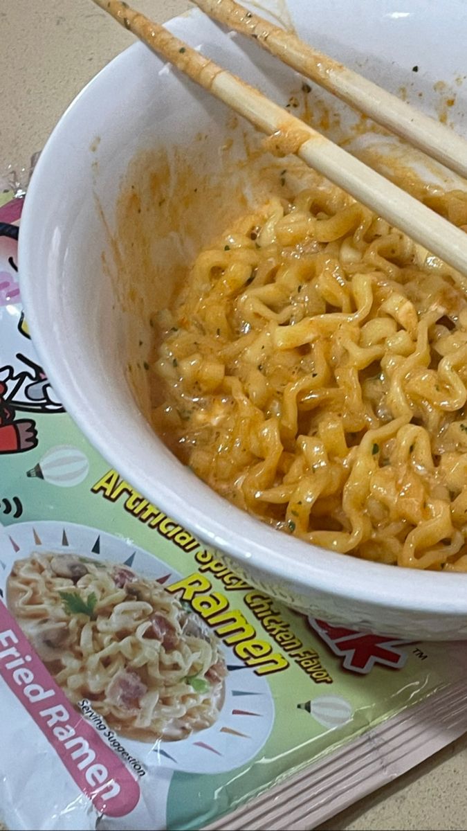 chopsticks sticking out of a bowl of noodles