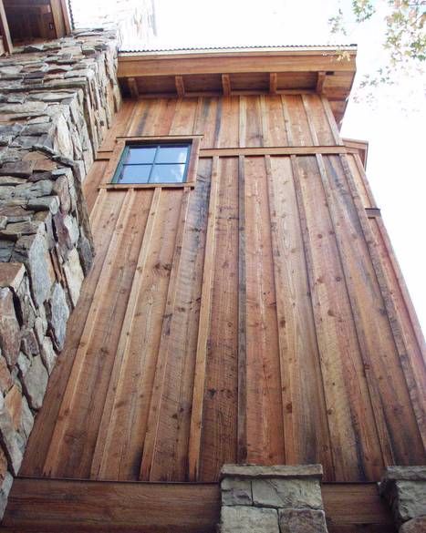 the side of a building made out of wood and stone with a window on it