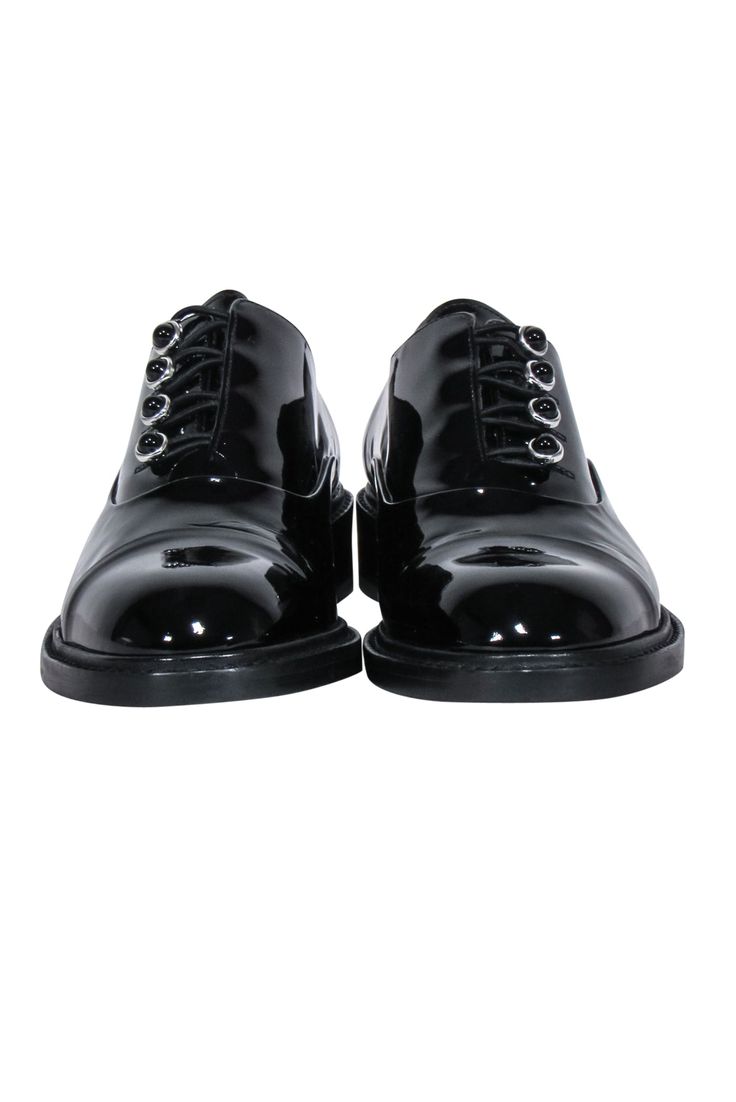 Slay the pavement with Stuart Weitzman's stylish black patent leather oxfords! These chic and sleek shoes will give any outfit an instant upgrade, making it easy to look sharp - just add high waist pants and a classic blazer. Step up your shoe style now! Size 6 Made in Spain Leather upper and lining Rubber sole Elastic stretch button front closure Rounded toe Toe to heel 10" Spring Patent Leather Oxfords For Office, Spring Office Patent Leather Oxfords, Classic Patent Leather Oxfords For Spring, Classic Patent Leather Dress Shoes For Spring, Sleek Patent Leather Pointed Toe Oxfords, Sleek Patent Leather Oxfords For Derby, Formal Black Glossy Oxfords, Elegant Black Glossy Oxfords, Sleek Patent Leather Oxfords With Round Toe