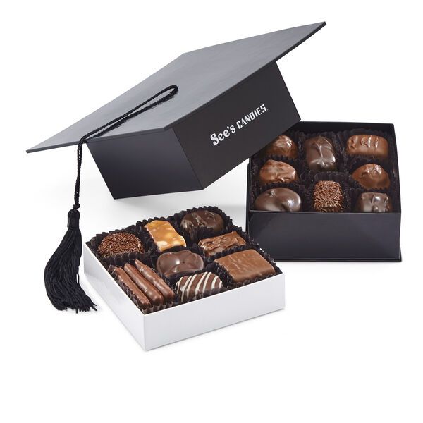 a graduation cap sits on top of a box of chocolates