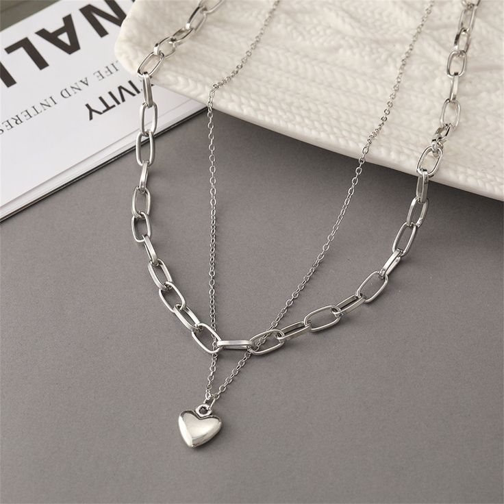 This shimmering silver-plated necklace brings hearts and chains to your jewelry collection. Pendant : 0.79" L Smallest chain: 16.93" L with 1.96" extender Largest chain: 17.12" L with 1.96" extender Lobster claw clasp Silver-plated copper Grunge Jewelry, Thick Chain Necklace, Double Layer Necklace, Heart Shaped Pendant Necklace, New Heart, Layer Necklace, Great Gifts For Mom, Layered Jewelry, Heart Shape Pendant