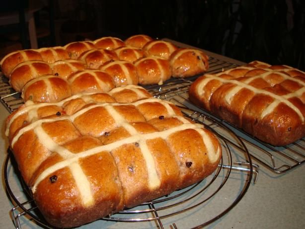 freshly baked hot cross buns cooling on racks