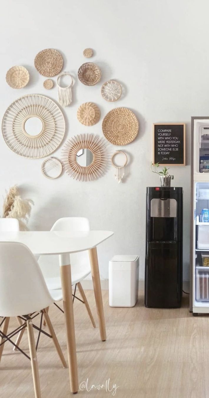 a kitchen with white chairs and a refrigerator in the corner that is decorated with wicker plates