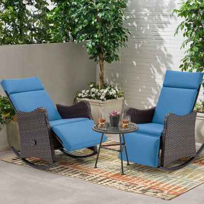 two chairs and a table sitting on top of a rug