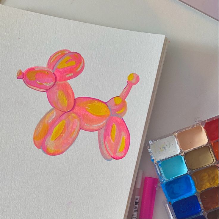 a drawing of a pink poodle on white paper next to watercolors and markers