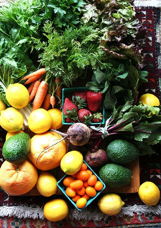 an assortment of fruits and vegetables on a rug