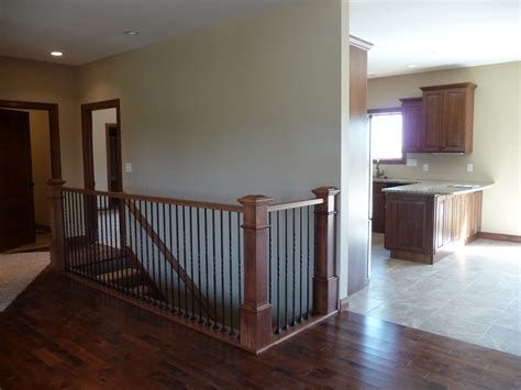 an empty living room with hard wood flooring and stairs leading up to the kitchen