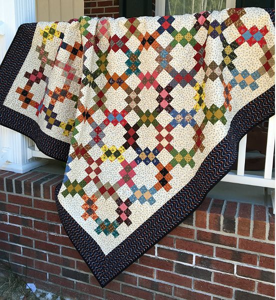 a quilt hanging from the side of a brick building